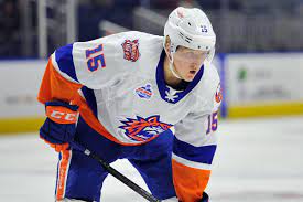 A hockey player in white and orange uniform.