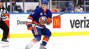 A hockey player is on the ice with his stick.