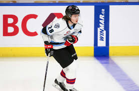 A hockey player is on the ice with his stick.