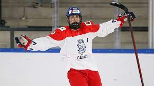 A man in red and white hockey uniform holding a frisbee.