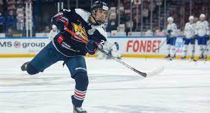 A hockey player is on the ice with his stick.