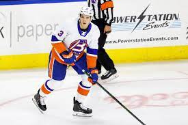 A hockey player is on the ice with his stick.