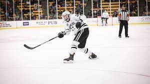 A hockey player is on the ice with his stick.